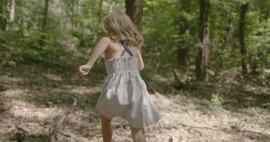 A girl runs in a forest