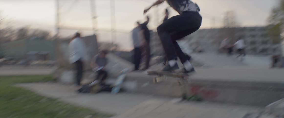 A man jumps on his skateboard in the park