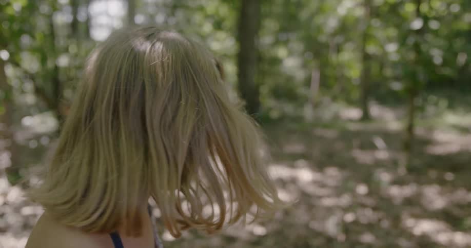 Little girl playing hide and seek in shady forest