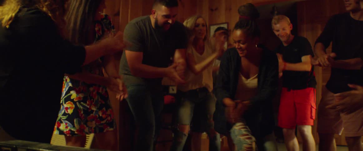 Group of people in living room are clapping and dancing