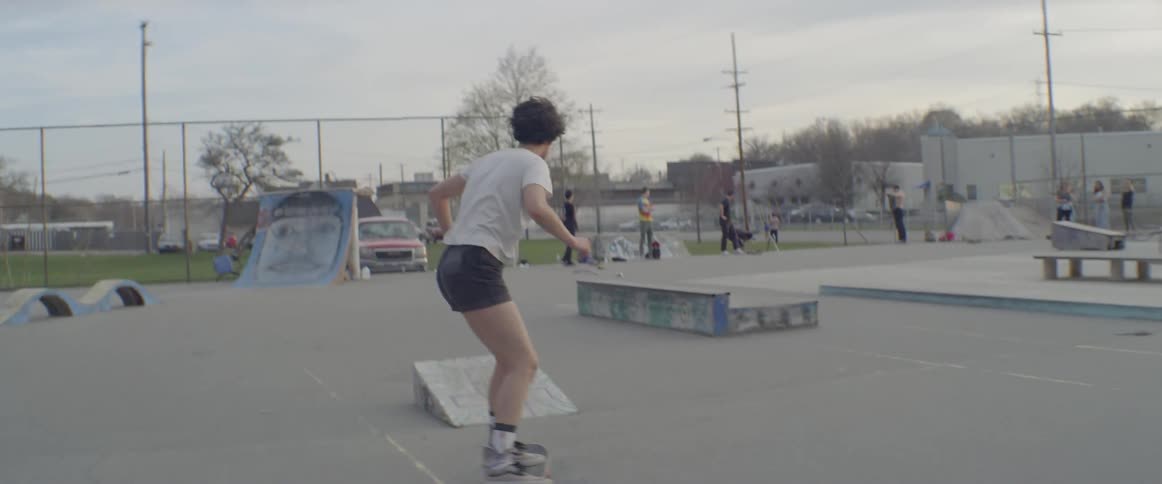 Girl on skateboard jumps off ramp in skate park