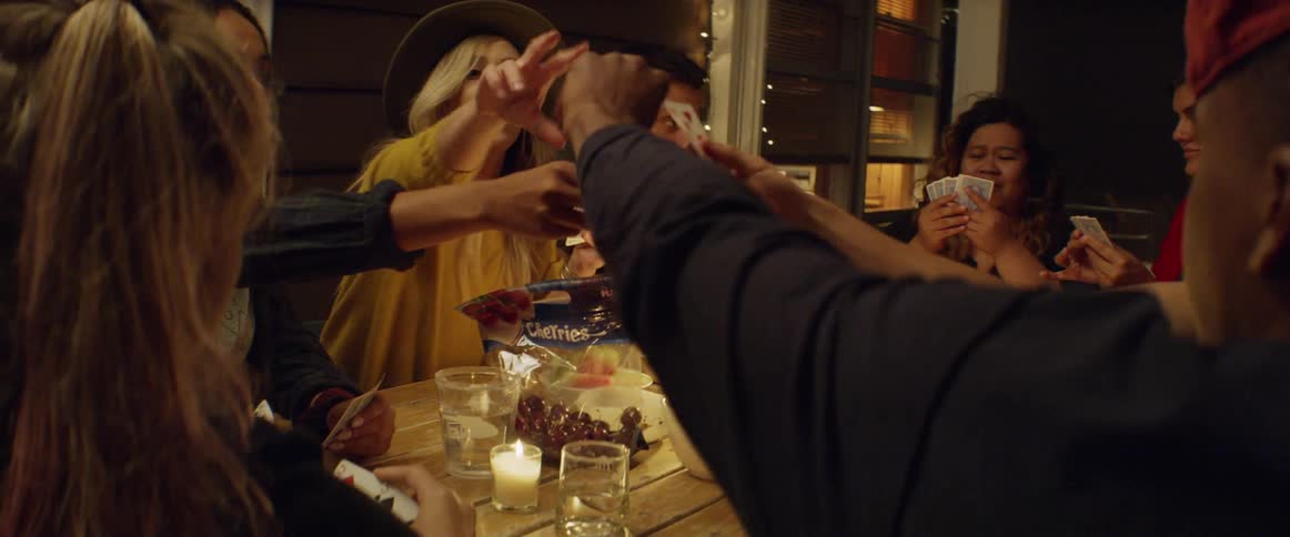 A group of people are playing cards at the table