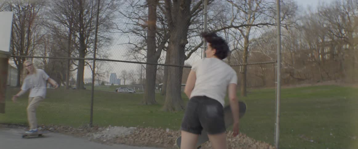 Girls try tricks on a skateboard in a skate park