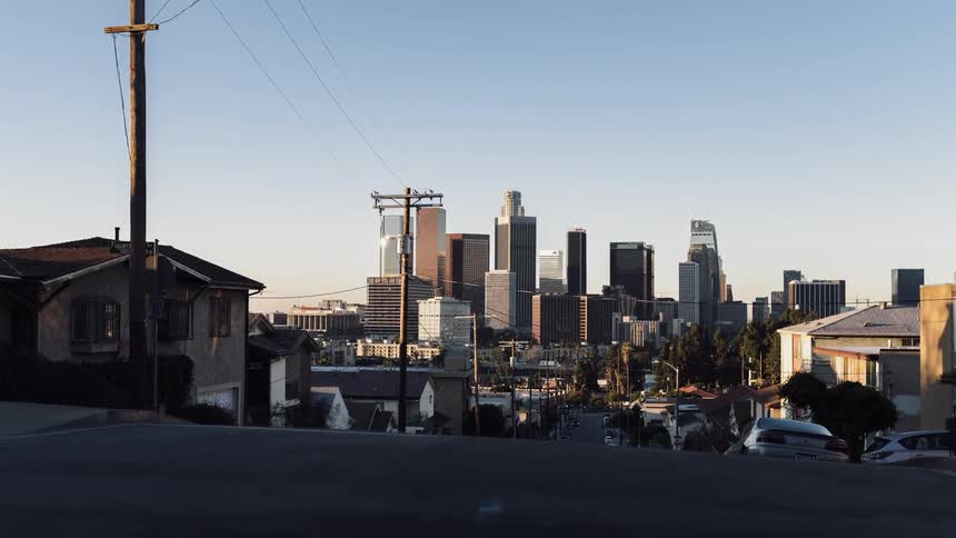 Road going down into a city at sunset