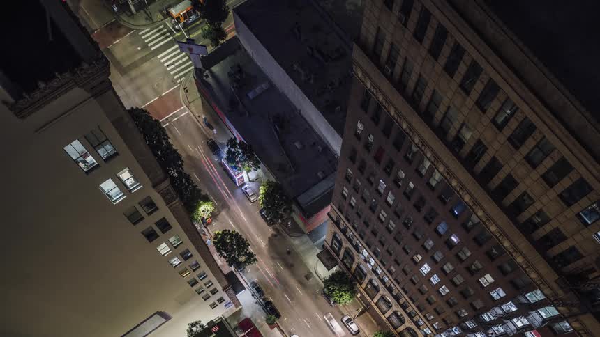 Traffic is flowing through an intersection in a city during the night