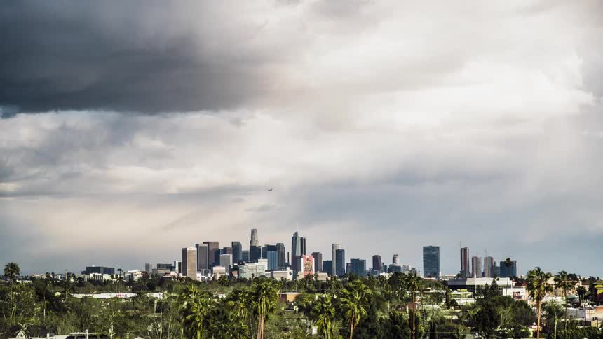 The heavy clouds pour rain over the city ahead