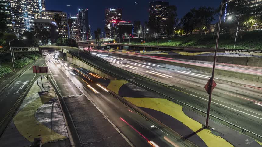 Cars drive on a city highway at night