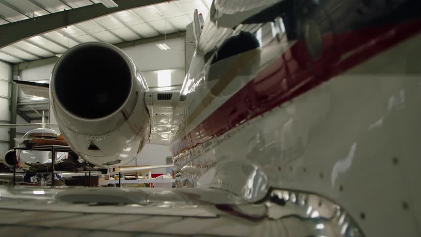 The jet in the hangar has a red stripe on the side