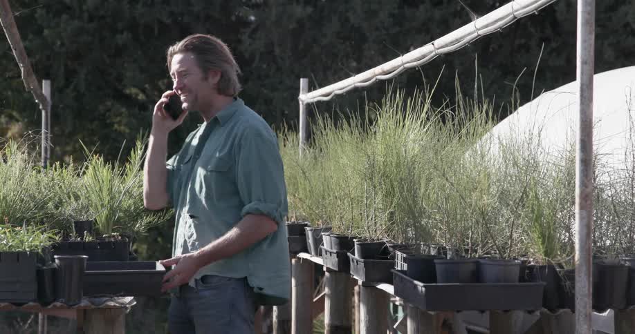 A man talks on his phone in the garden