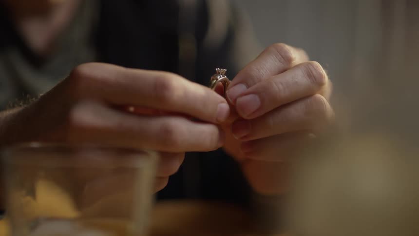 The man lifts the ring up holding it with both hands