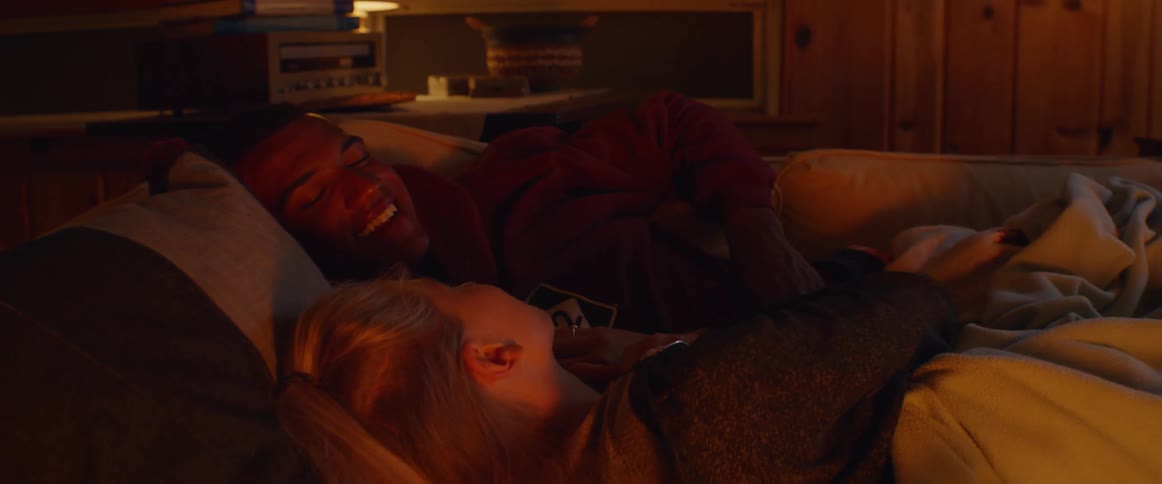 A man and woman lay in bed talking
