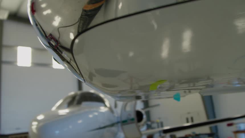 Under wing of a plane in a hangar with other planes
