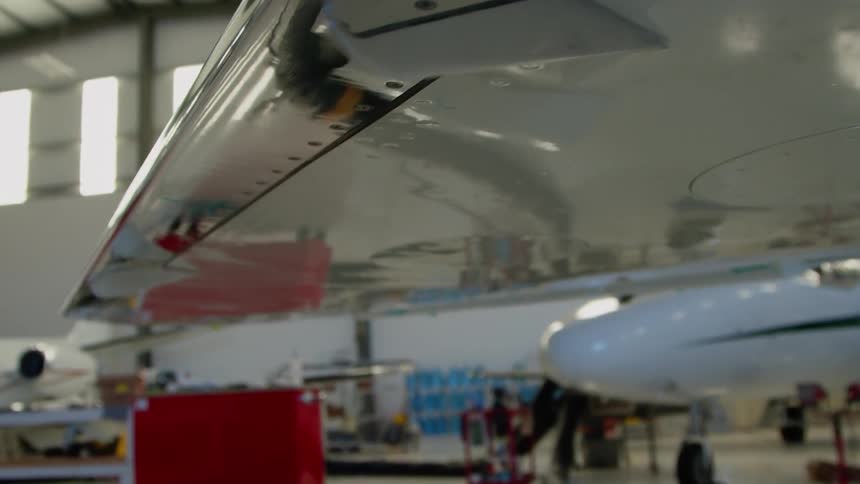 Airplanes in a large airplane garage with the sun shining in