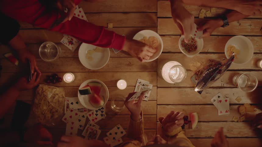 Group of people are playing card game at table