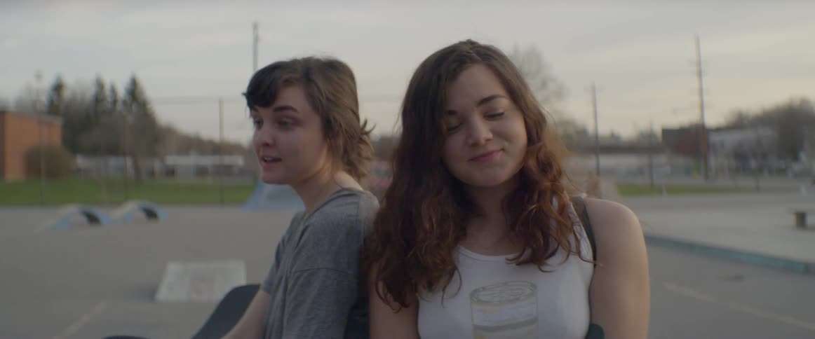Two girls laugh and talk with each other