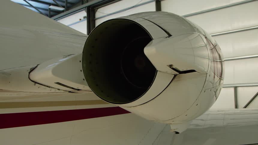 Engine sits attached to an airplane inside a hangar