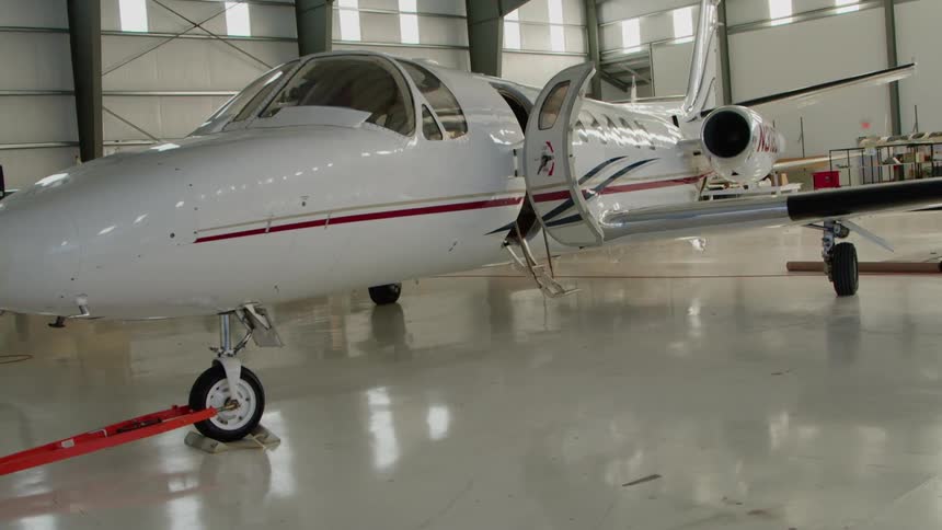 White and red airplane sits in a hangar