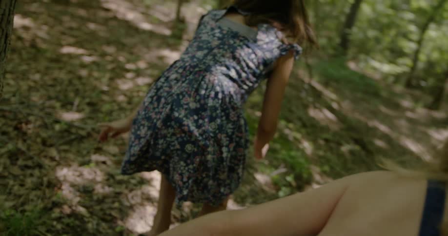Girls laugh and play in the woods on a sunny day