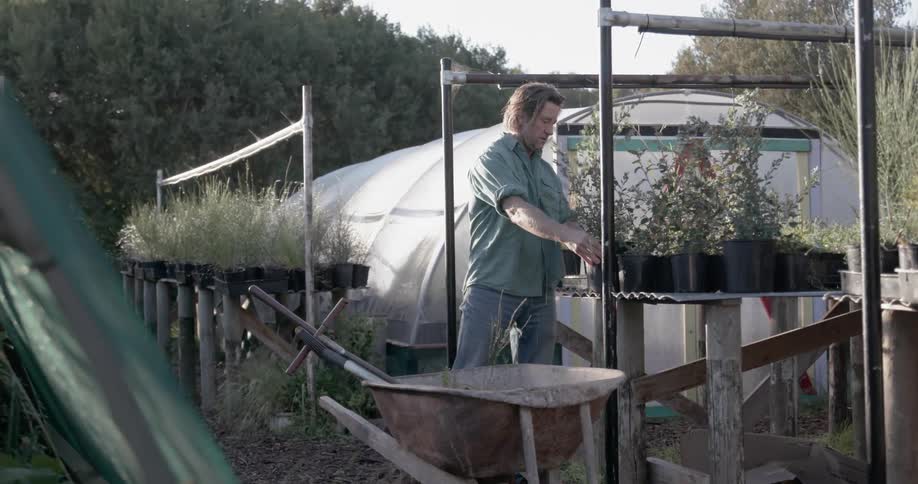 A man works in the garden on a cloudy day