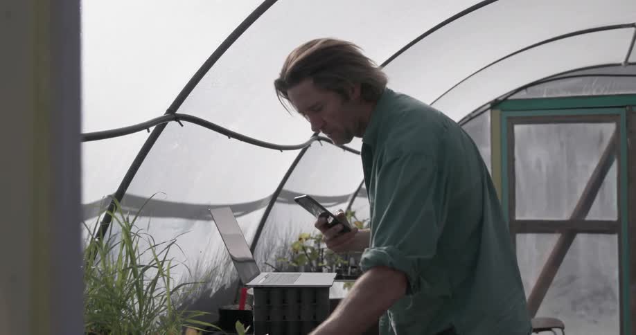 Man takes a picture of a plant with his phone