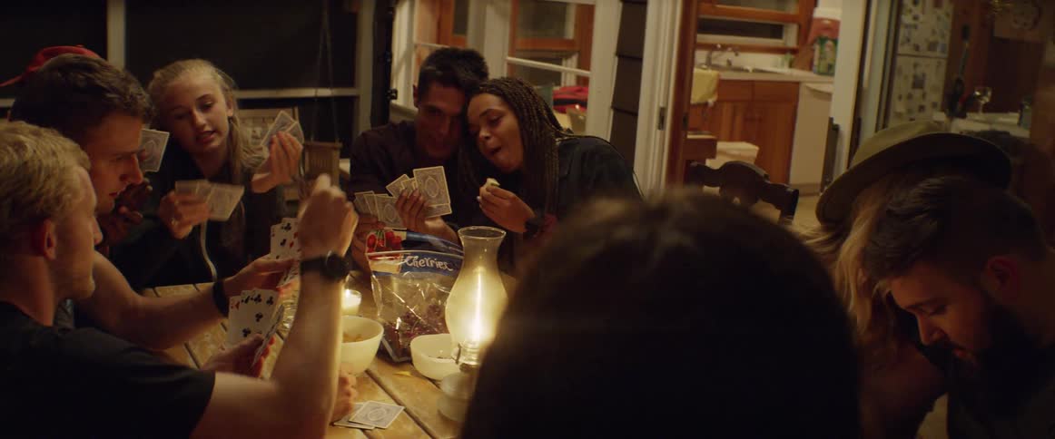 A group of people play cards and talk together