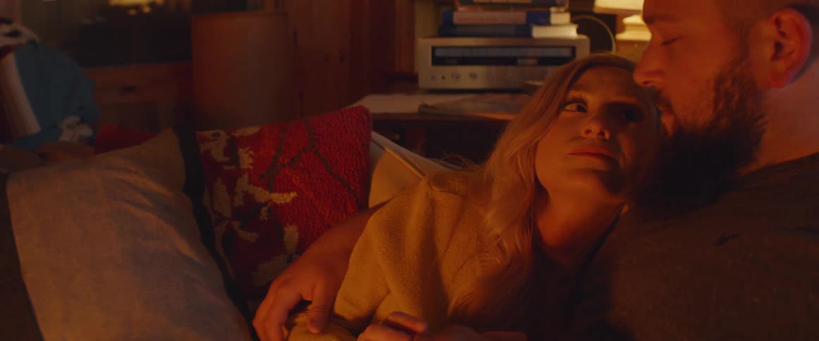A man and woman cuddle together on the couch