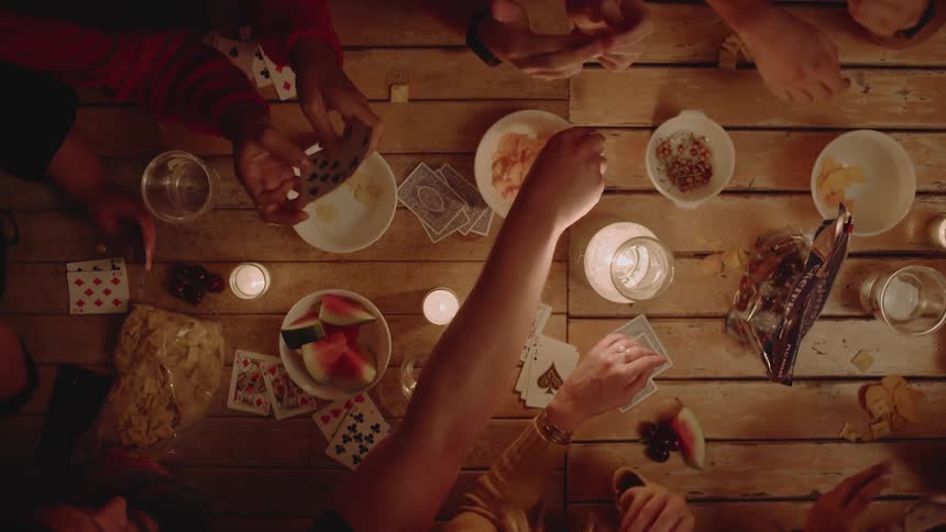 Friends play cards and eat snacks