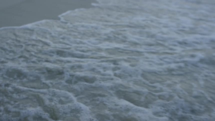 The waves splash against the people standing in the stand