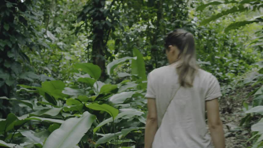 A woman walks around searching in the forest
