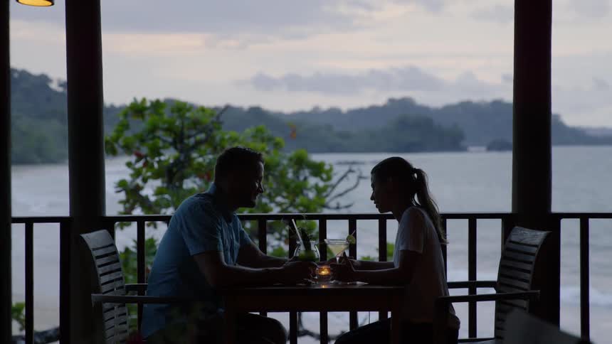 Two people sit together on the porch for a drink