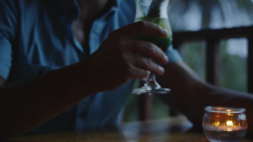 Man sitting at table takes a drink of his beverage