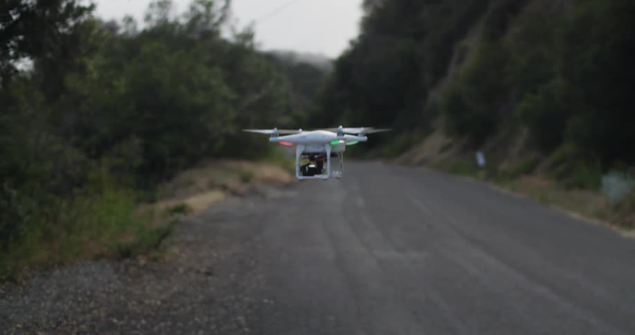 A drone flies over a rural road