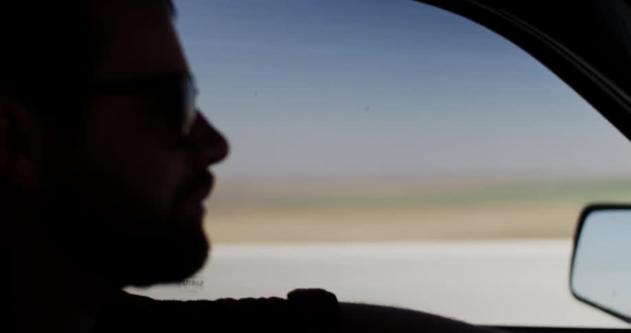 Man driving a vehicle with fields on his side