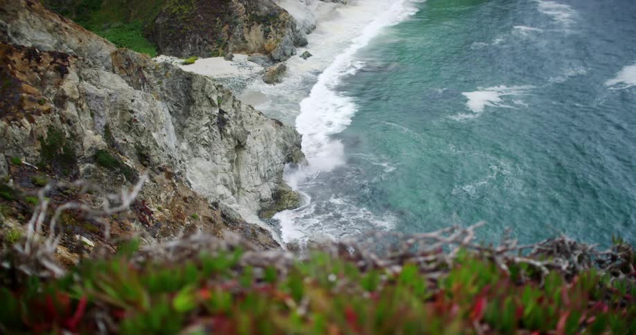 Waves crash against a rocky shore and beach