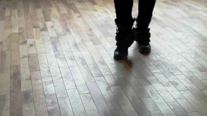 Someone sliding their feet backwards and then stopping, on a wood floor