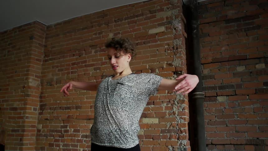 A woman is dancing indoors by herself