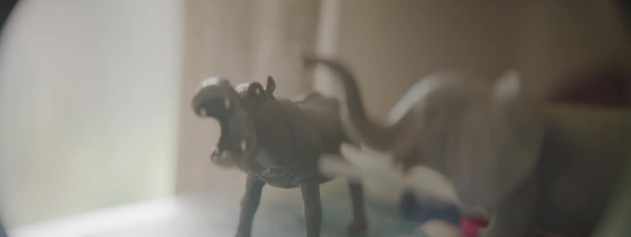 Animal figurines are displayed on a bedroom table
