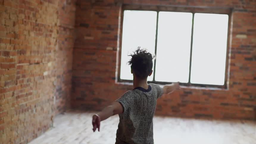 Woman jumping around and twirling in a room