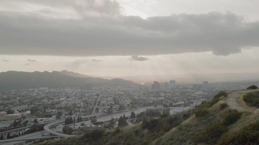 Part of a large city sitting in a valley on a cloudy day