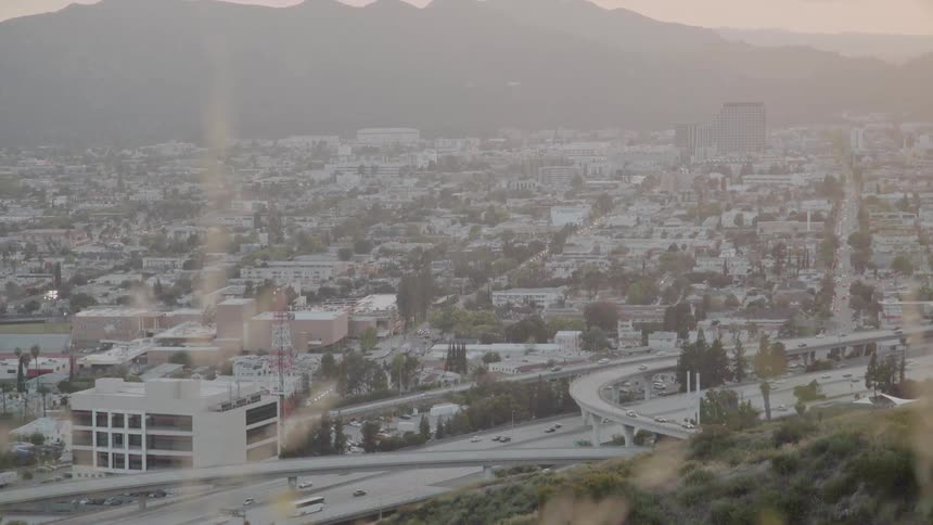 Cars drive on a city highway at sunset