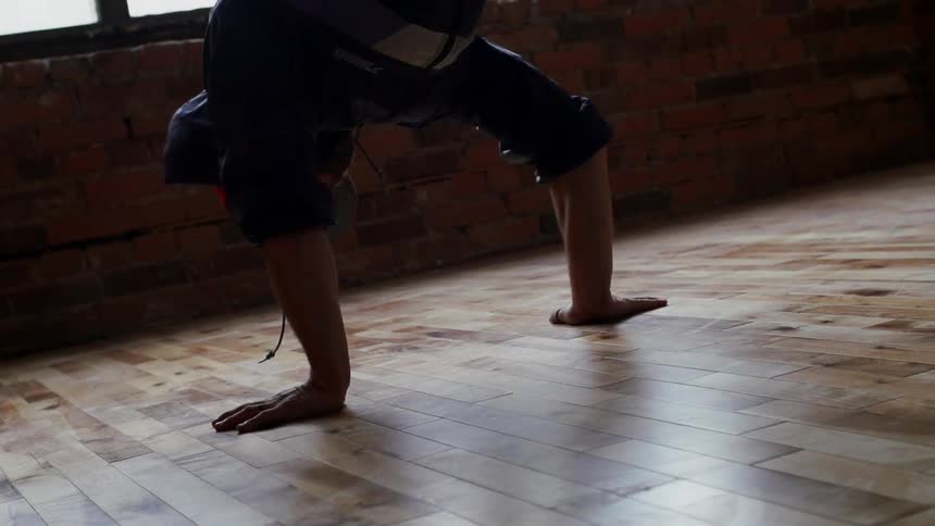 Person break dancing on a wood floor
