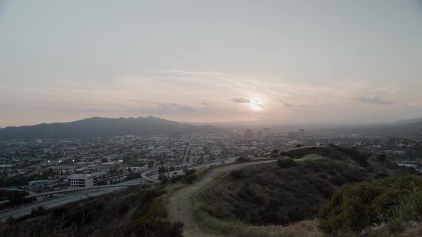 The sun is nearly set over the city below
