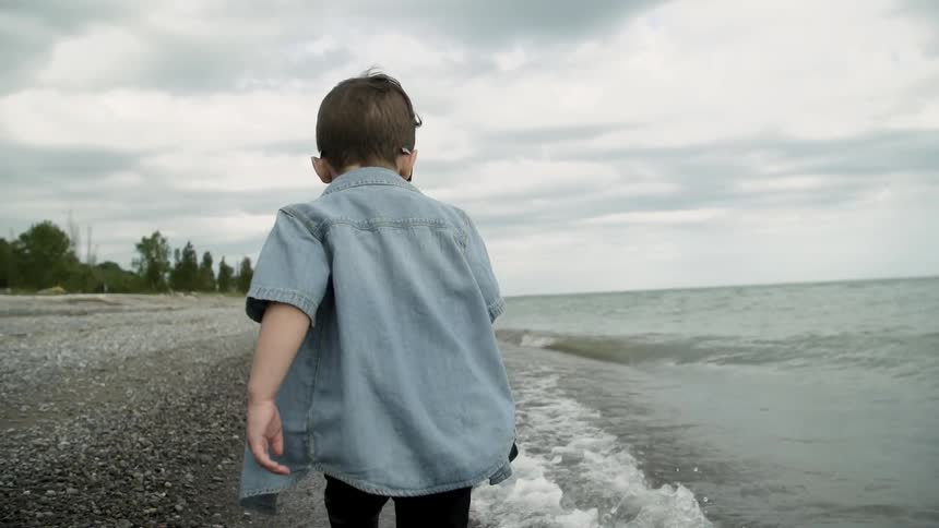 A child runs on the empty beach as waves come to shore