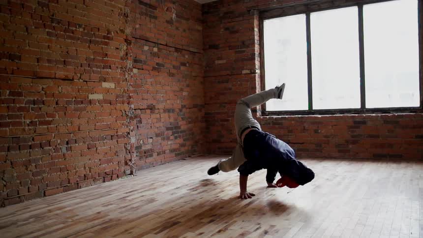 Man break dancing on a wooden floor