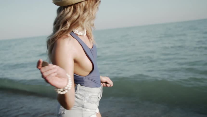 A woman walks into the surf of the shore
