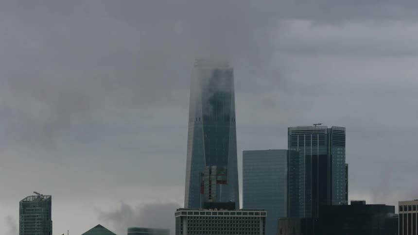 Clouds move around the top of a skyscraper
