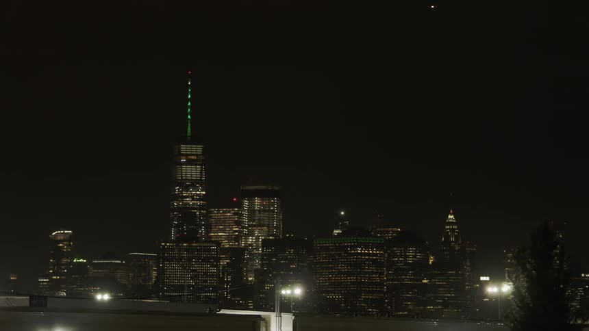The tall building has flashing lights at the top