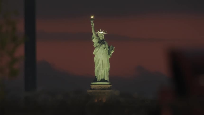 The statue of liberty at sunset comes into focus