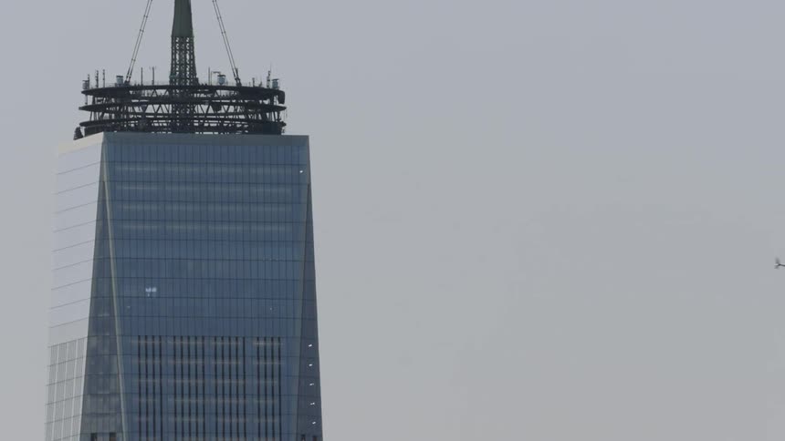 A helicopter flies past the sky scraper