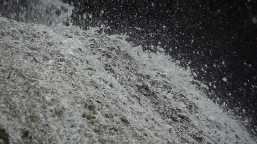 Water splashing up as it hits rock before flowing down